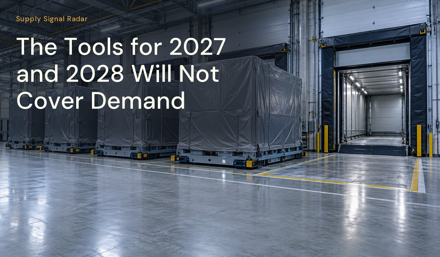 Large crated machine modules on a loading dock, with one space at the end of the row still empty.